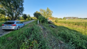 radiowóz policyjny w miejscu dachowania pojazdu do rowu.