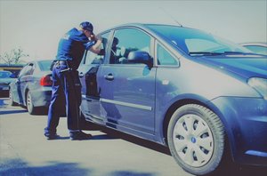 policjant zaglądający do auta.
