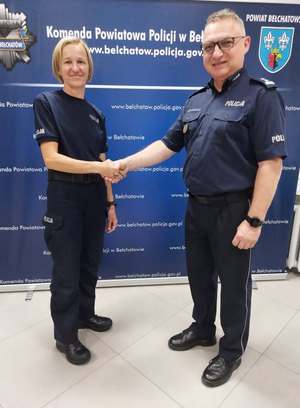 komendant policji wita nowo przyjętą policjantkę. zdjęcie zrobione w auli komendy.