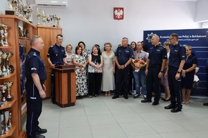uroczyste spotkanie policjantów i pracowników cywilnych Policji. W auli komendy uroczystość służbowa związana z odejściem na emeryturę pracownicy cywilnej. Komendanci składają życzenia kobiecie. Komendant zajmuje miejsce przy mównicy.