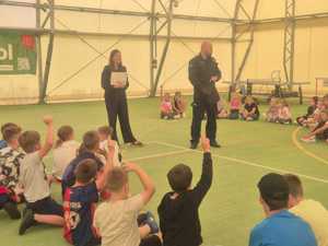 policjant na spotkaniu z dziećmi uczestniczącymi w półkoloniach w Powiatowym Centrum Sportu.