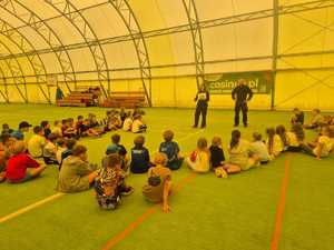 policjant na spotkaniu z dziećmi uczestniczącymi w półkoloniach w Powiatowym Centrum Sportu.