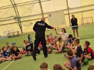 policjant na spotkaniu z dziećmi uczestniczącymi w półkoloniach w Powiatowym Centrum Sportu.