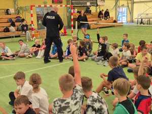 policjant na spotkaniu z dziećmi uczestniczącymi w półkoloniach w Powiatowym Centrum Sportu.