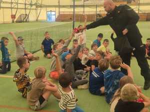 policjant na spotkaniu z dziećmi uczestniczącymi w półkoloniach w Powiatowym Centrum Sportu.
