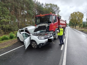 wypadek drogowy w Józefowie, gdzie zderzyły się dwa pojazdy osobowy i ciężarówka. Przy pojazdach stoi policjantka, która prowadzi oględziny pojazdów.