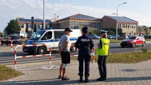 działania policji pod szkołą w ramach akcji bezpieczna droga do szkoły.policjantki rozmawiają z mężczyzna.