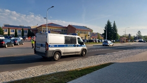 działania policji pod szkołą w ramach akcji bezpieczna droga do szkoły. radiowozy policyjne w rejonie szkoły.