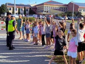 policjantki uczą dzieci prawidłowych zachowań w rejonie przejść dla pieszych.