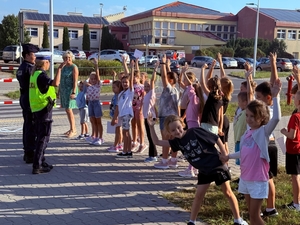 policjantki uczą dzieci prawidłowych zachowań w rejonie przejść dla pieszych.