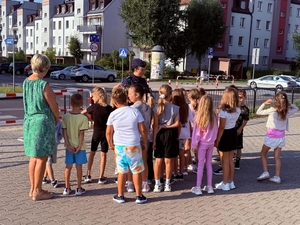 policjantki uczą dzieci prawidłowych zachowań w rejonie przejść dla pieszych.