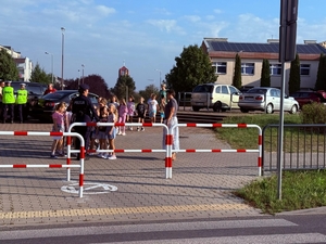 policjantki uczą dzieci prawidłowych zachowań w rejonie przejść dla pieszych.