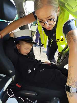 policjantka pokazuje dziecku radiowóz.