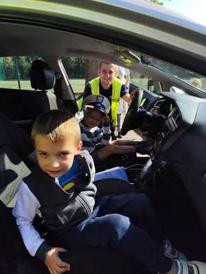 policjant pokazuje dzieciom radiowóz.