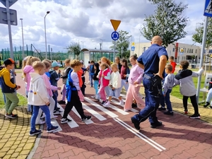 policjanci uczą dzieci prawidłowych zachowań na przejściu dla pieszych.