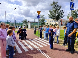policjanci uczą dzieci prawidłowych zachowań na przejściu dla pieszych.