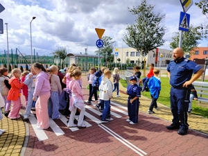 policjanci uczą dzieci prawidłowych zachowań na przejściu dla pieszych.