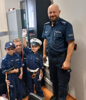 policjant z dziećmi w pomieszczeniu służbowym.