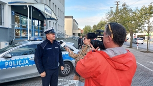 policjant udzielający wywiadu przed komendą Policji.