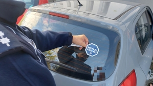 policjant wręcza kierowcy ulotkę.