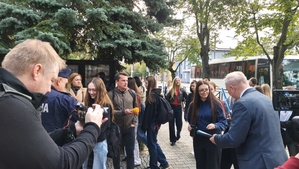 zdjęcie z akcji Odblaski ratują życie, która była wspólną akcją Policji i Starostwa Powiatowego w ramach kampanii „Bezpieczna droga do szkoły”. Na zdjęciu Komendant i Starosta Bełchatowski,  przed budynkiem szkoły. Komendant i Starosta rozdają uczniom odblaski.