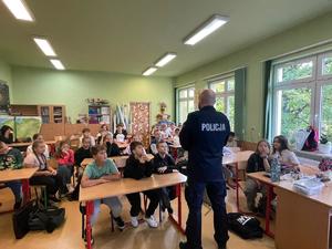 policjant na spotkaniu z uczniami w szkole.