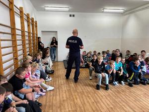 policjant na spotkaniu z uczniami w szkole.