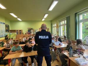 policjant na spotkaniu z uczniami w szkole.