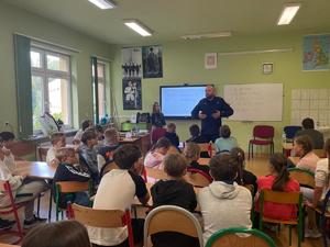 policjant na spotkaniu z uczniami w szkole.
