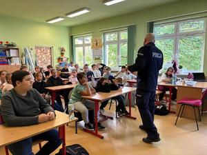 policjant na spotkaniu z uczniami w szkole.