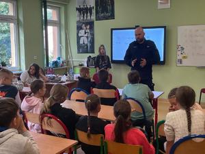 policjant na spotkaniu z uczniami w szkole.