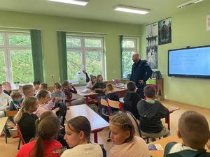 policjant na spotkaniu z uczniami w szkole.