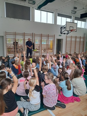 policjant na spotkaniu z uczniami w szkole.