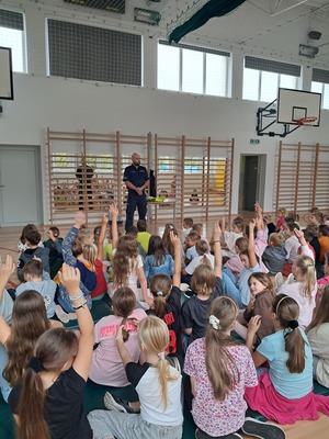 policjant na spotkaniu z uczniami w szkole.