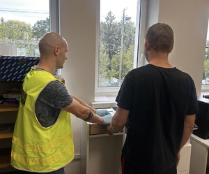 Policjant zbiera odciski palców od mężczyzny.