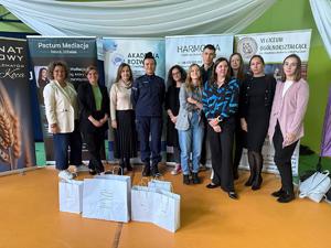 Zdjęcie grupowe policjantki z nauczycielami i gośćmi.