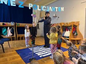 Policjantka pokazuje jak prawidłowo przechodzić przez pasy przejścia dla pieszych.