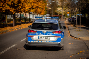Tył radiowozu jadący jezdnią.
