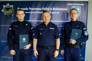 Komendant wraz z dwoma policjantami pozują do zdjęcia.