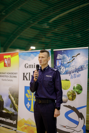 Komendant wypowiadający się do mikrofonu.