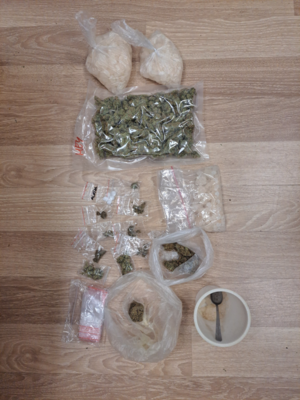 Narkotyki w opakowaniach znajdujące się na stole.