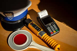 Tarcza do zatrzymywania pojazdów, alcoblow, terminal i biała czapka policyjna.