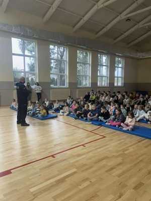 Policjant stoi przed grupą dzieci.