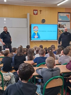 Policjanci stoją przed grupą dzieci.