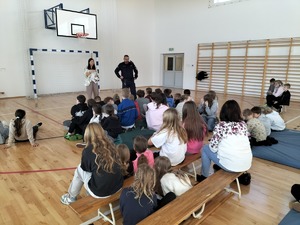 Policjant stoi przed grupą dzieci.