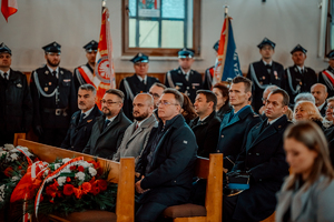 Komendant wraz z innymi przedstawicielami instytucji państwowych siedzą w ławce w kościele.