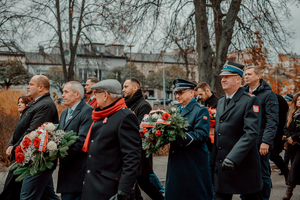 Komendant wraz z innymi przedstawicielami instytucji państwowych maszerują ulicą.