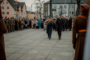 Komendant Powiatowy Policji wraz z Komendantem Straży Pożarnej składają kwiaty pod pomnikiem.