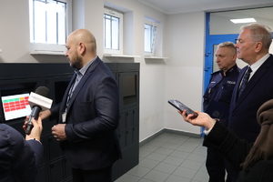 Kierownik Ogniwa Łączności i Informatyki Komendy Powiatowej Policji w Bełchatowie stoi przy depozytariuszu.