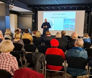 Policjant stoi przed seniorami.